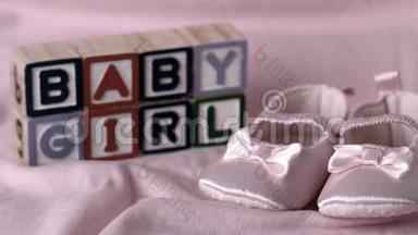 婴儿鞋掉在粉红色的毯子上，宝贝女孩的信息在街区内